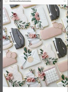 decorated cookies are arranged on a table with flowers and other items in the shape of envelopes