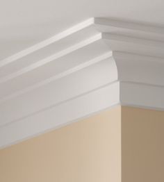 the corner of a room with white paint and molding on the ceiling above it