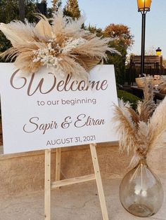 a welcome sign sitting on top of a wooden easel next to a lamp post