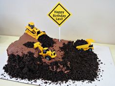 a birthday cake made to look like a construction site with dump trucks on it and a sign that says happy birthday level