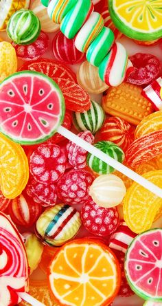 colorful candies and lollipops are arranged in the shape of fruit slices