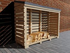 a firewood rack with logs in front of a brick wall and wooden slats