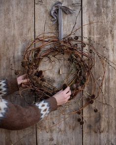 a person holding a wreath with twigs on it