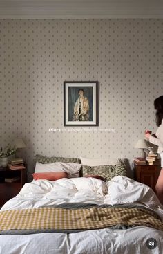 a woman standing in front of a bed