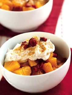 two white bowls filled with food on top of a red table cloth next to each other