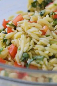 a bowl filled with pasta and vegetables on top of a table