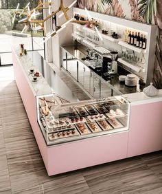 an ice cream shop with pink counter tops and shelves filled with desserts, pastries and condiments