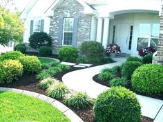 a house with landscaping in front of it and bushes on the side of the house