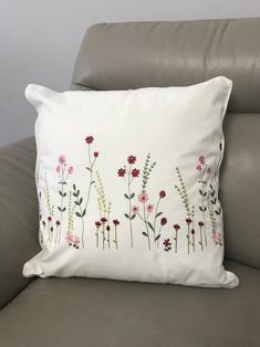 a white pillow with pink and red flowers on it