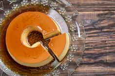 an orange dessert in a glass bowl on a wooden table