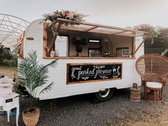 an old camper converted into a food truck with plants growing out of the back