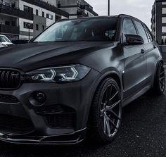 a black bmw suv parked on the street