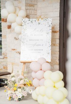 balloons and flowers are on display in front of a welcome sign