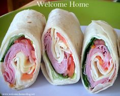 there is a wrap with meat and vegetables in it on a white plate that says welcome home