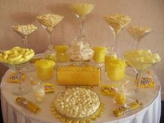 a table topped with lots of desserts next to wine glasses and cups filled with candy