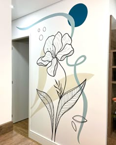 a wall with flowers painted on it in a room next to a book shelf and shelves