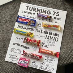 some candy bars are sitting on top of a sign that says, turning 75 is nothing to say about