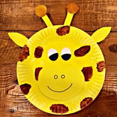 a paper plate with a yellow giraffe face on it's side and brown spots around the eyes