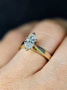 a woman's hand with a yellow gold ring and diamond engagement ring on it