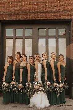 a group of women standing next to each other in front of a door wearing green dresses