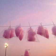 several pieces of meat hanging from a line with lights in the background at night time