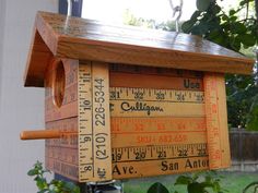 a wooden birdhouse with measuring tape on it