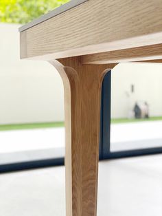 a close up view of a wooden table with an open door in the back ground