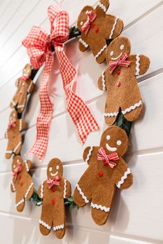 a wreath made out of gingerbreads on a white wall with red gingham ribbon