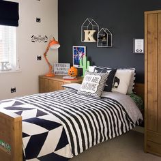 a bedroom decorated in black and white with halloween decorations on the wall above the bed