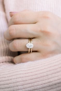 a close up of a person wearing a ring with a diamond on the middle finger