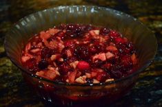 a glass bowl filled with cranberry sauce on top of a counter