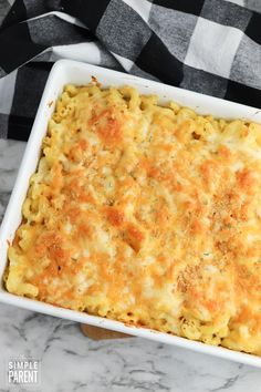 a casserole dish with cheese and parmesan in it on a marble surface