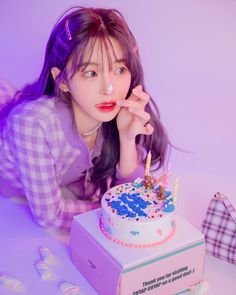 a woman laying on the ground next to a birthday cake