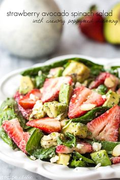 strawberry avocado spinach salad with creamy poppy seed dressing on a white plate