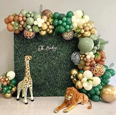 an animal and giraffe themed backdrop for a baby's first birthday