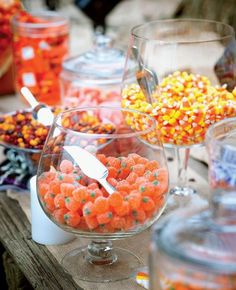 there are many candy in glass bowls on the table