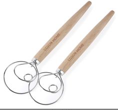 two stainless steel utensils with wooden handles on white background, one has the word gon written on it