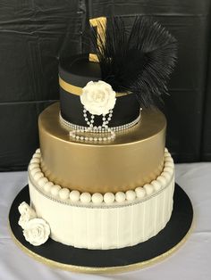 a three tiered cake with black, white and gold decorations