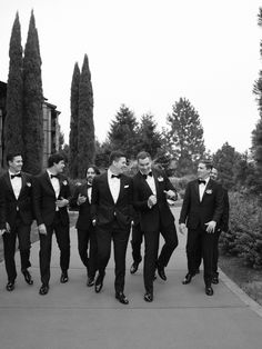 a group of men in tuxedos walking down a street