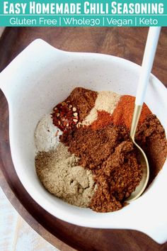 a bowl filled with spices on top of a wooden table