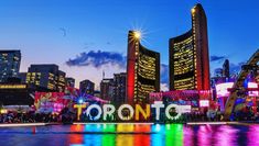 the word toronto lit up in front of some tall buildings