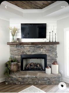 a fireplace with a flat screen tv mounted above it and candles on the mantel