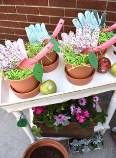 several potted plants and gardening utensils sitting on a table with flowers in them