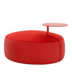 a red round table sitting on top of a white floor next to a chair and ottoman