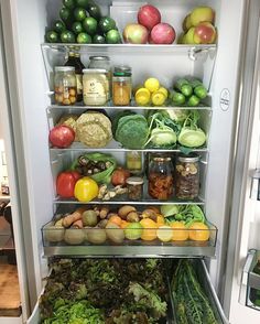 an open refrigerator filled with lots of different types of vegetables and fruits, including lettuce