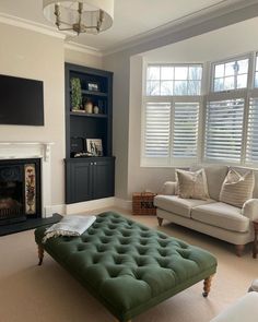 a living room filled with furniture and a flat screen tv mounted on the wall above a fireplace