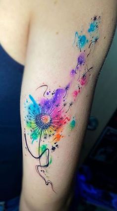 a woman's arm with a colorful flower tattoo on the left side of her body