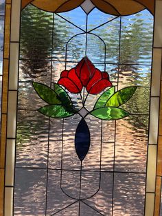 a stained glass window with red flowers on the bottom and green leaves in the middle