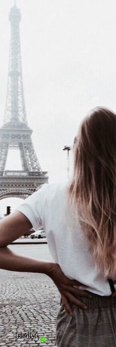 a woman standing in front of the eiffel tower