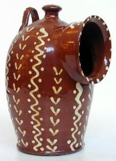 a brown and white vase sitting on top of a table